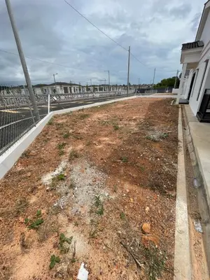 a dirt road next to a building with a fence at Nadine Homestay in Sungai Petani