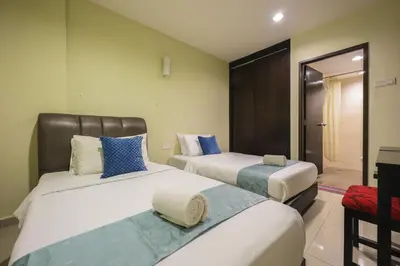 two beds in a hotel room with a mirror at Marina Island Lumut 3 Bedroom Holiday Apartment in Lumut