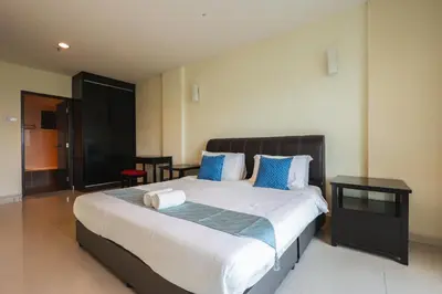 a bedroom with a large bed with blue pillows at Marina Island Lumut 3 Bedroom Holiday Apartment in Lumut