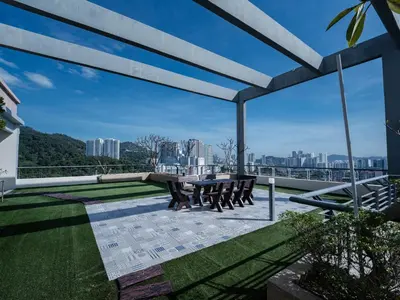 a patio with a table and chairs on a roof at 22 Penthouse by BRB, Airport View & 18 Pax in Bayan Lepas