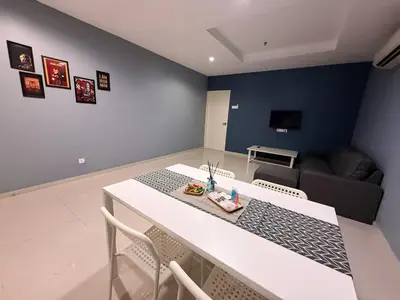 a living room with a table and chairs and a couch at IRONMAN HomeStay in Lumut