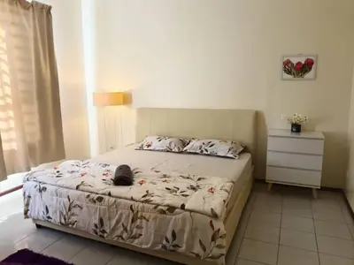 a bedroom with a bed with a cat laying on it at Homestay Bajet EM3 Pantai Damai 2 in Pantai Remis