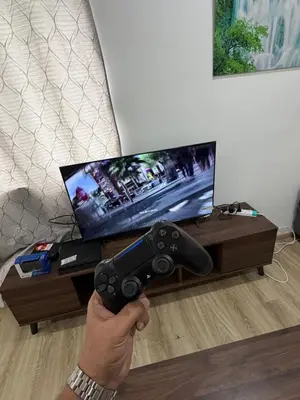 a person holding a video game controller in front of a tv at AYAAN ATRIUM Homestay with PS4 GAMING and Snookers in Tanah Rata