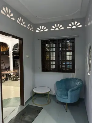 a living room with a blue chair and a table at Homestay Laman Kasih Mama in Seri Manjung