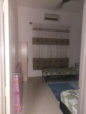 a small room with two beds and a window at Sakeena Homestay in Padang Serai