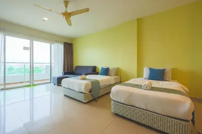 a hotel room with two beds and a couch at Marina Island Lumut Homestay in Lumut