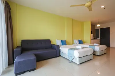 a hotel room with two beds and a couch at Marina Island Lumut Homestay in Lumut