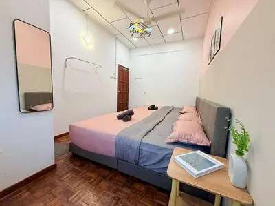 a small bedroom with a bed and a table at CozyKota8Pax 4MinsToJonker in Gua Sai