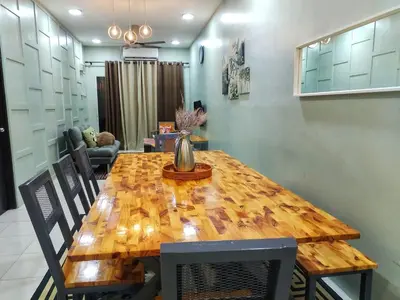 a wooden dining room table with chairs and a vase on it at D'mesyar Homestay 3BR Fully airconds in Teluk Intan