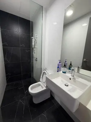 a bathroom with a sink and a toilet and a mirror at Beacon Executive Suites with Infinity Pool by BNB4U in George Town