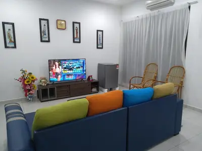 a living room with a blue couch and a tv at Pangkor Villa Jia Yuan \u90a6\u54af\u5c9b\u5bb6\u82d1\u6d77\u6ee9\u522b\u5885 in Pangkor