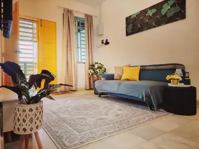 a living room with a blue couch and a yellow door at Kuda Kepang Guesthouse in Sungai Petani
