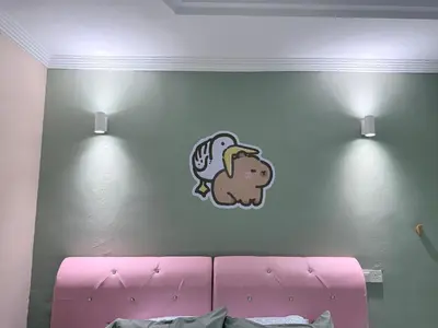 a bedroom with a pink couch with a sticker on the wall at Capy House Taiping in Taiping