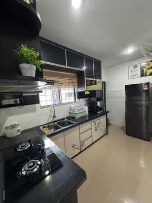 a kitchen with a stove and a sink in it at D' Mutiara Homestay in Simpang Ampat