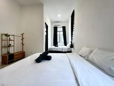 a white bedroom with a large white bed and two windows at 4BR Cozy Villa for 16 Pax Quiet Area & Spacious in Simpang Ampat