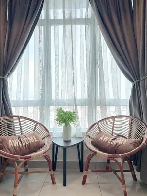 two chairs and a table in front of a large window at Homii Ipoh CBD in Ipoh