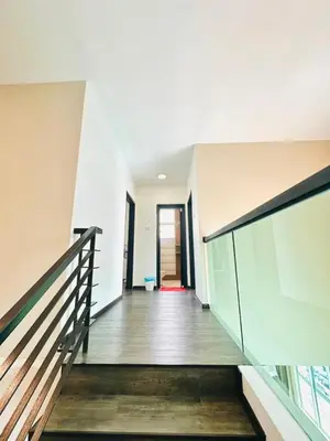 a staircase in a house with a glass railing at Homestay Golden Hills Apartment Penthouse in Brinchang