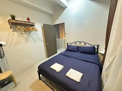 a bedroom with a blue bed with two pillows at Homestay Golden Hills Apartment Penthouse in Brinchang