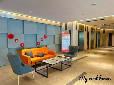 a lobby with an orange couch and two chairs at Sunway Onsen Suite Theme Park View 2BR in Ipoh