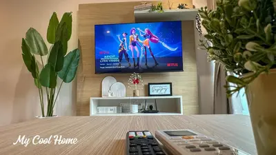 a living room with a tv and a table with a remote control at Sunway Onsen Suite Theme Park View 2BR in Ipoh