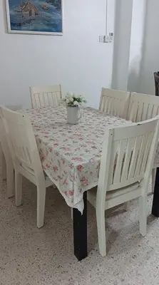 a table with two chairs and a table with a tablecloth at Sutera Homestay in Sungai Petani