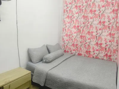 a bedroom with a bed and a curtain with flowers at Ian's homestay II tanahrata chighlands in Tanah Rata