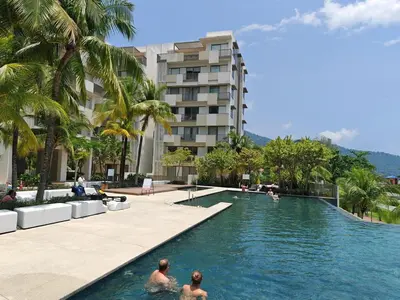 people swimming in a swimming pool in front of a building at By the sea Beach Front, Seaview And Pool side in Batu Ferringhi