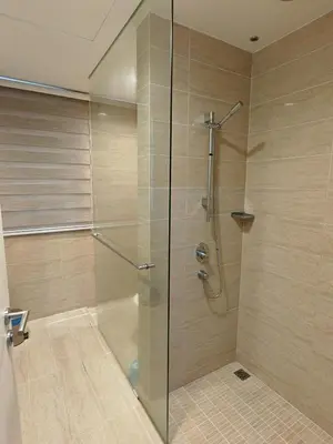 a shower with a glass door in a bathroom at By the sea Beach Front, Seaview And Pool side in Batu Ferringhi