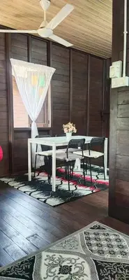 a dining room with a white table and chairs at Pak Ayie Homestay in Batu Kurau