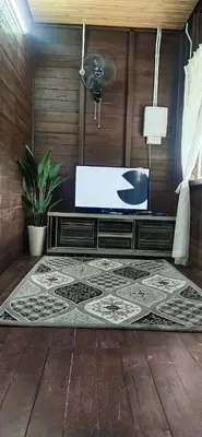 a bathroom with a tub and a rug on a wooden floor at Pak Ayie Homestay in Batu Kurau