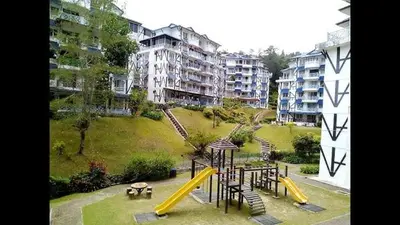 a playground with a yellow slide in a park at Cameron Highland 3 Bedroom Apartment in Cameron Highlands