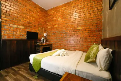 a room with two beds and a brick wall at Anggun Hotel in Seri Iskandar