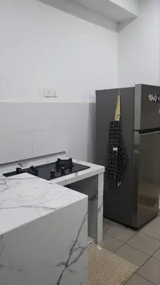 a kitchen with a stove and a refrigerator at Homestay PPAM Dalur Apartment Presint 18,Putrajaya in Gua Sai