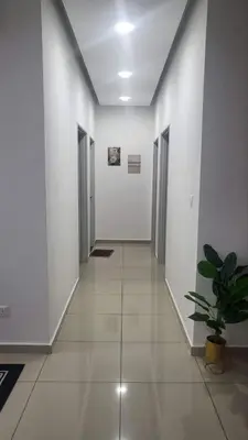 a hallway with white walls and a potted plant at Homestay PPAM Dalur Apartment Presint 18,Putrajaya in Gua Sai