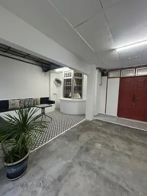 a garage with a red door and a potted plant at Comfortable two-storey terrace house near main road perai in Perai