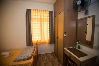 a small room with a bed and a window at Jean CleanComfy Apt Near Beach in Batu Ferringhi