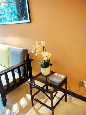 a coffee table with a vase of flowers on it at Jean CleanComfy Apt Near Beach in Batu Ferringhi