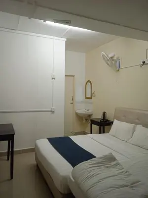 a bedroom with a bed and a sink in it at Netasha Holiday INN in Tanah Rata