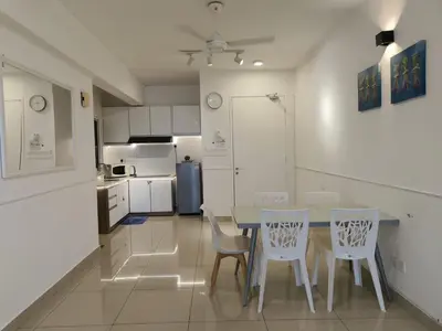 a kitchen with a table and chairs and a refrigerator at Heart of Ipoh 2BR 6pp in Ipoh