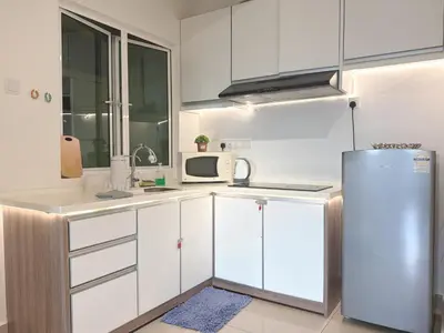 a kitchen with white cabinets and a refrigerator at Heart of Ipoh 2BR 6pp in Ipoh