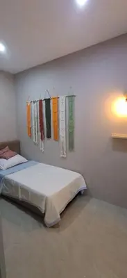 a bedroom with a bed and clothes hanging on a wall at Cozy Nook in George Town