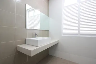 a white bathroom with a sink and a mirror at Shamrock Beach Villas 15 Seaview in George Town