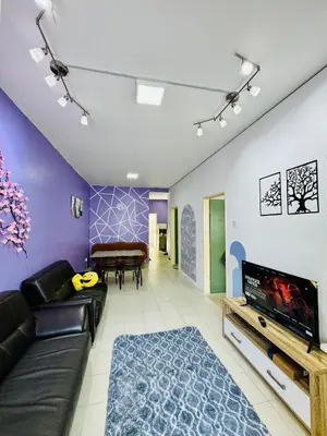 a living room with a couch and a flat screen tv at AYAAN LAVENDER Homestay with PS4 Gaming and Netflix at Tanah Rata Cameron Highland in Tanah Rata