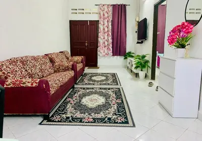 a living room with a couch and a rug at Homestay Hayyan