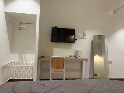 a room with a desk and a tv on a wall at MR Homestay HotelStyle Room Hutan Melintang in Hutan Melintang