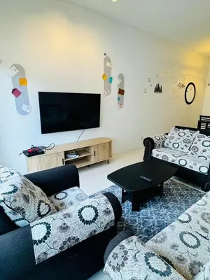 a living room with couches and a flat screen tv at AYAAN HOLIDAY INN Homestay at Tanah Rata with PS4 gaming in Tanah Rata