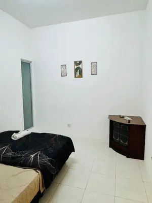 a white room with a bed and a wooden table at AYAAN HOLIDAY INN Homestay at Tanah Rata with PS4 gaming in Tanah Rata
