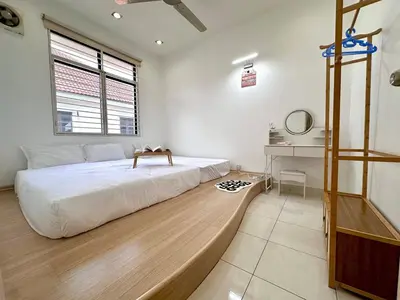 a bedroom with a large bed and a desk at Raja Uda Family Haven 4BR 10 Pax in Butterworth