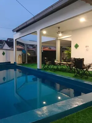 a swimming pool in front of a house at Putra Villa Homestay Ipoh in Ipoh