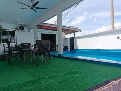 a patio with chairs and a swimming pool at Putra Villa Homestay Ipoh in Ipoh